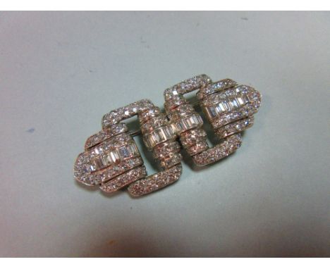 A French art deco odeonesque diamond and platinum brooch, of pierced double buckle form, with a central band of graduated bag