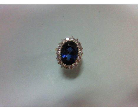 A large sapphire and diamond cluster ring, the oval cut deep blue sapphire, estimated weight 9.56cts, in a border of round br