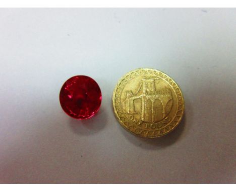 A loose synthetic ruby weighing 9.45cts, the oval mixed cut ruby - brilliant cut crown and step cut pavilion - of intense and