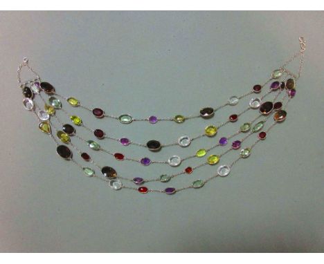 A five strand multi gemset necklace, composed of oval cut hessonite garnets, prasiolites, amethysts, smoky quartzes, citrines