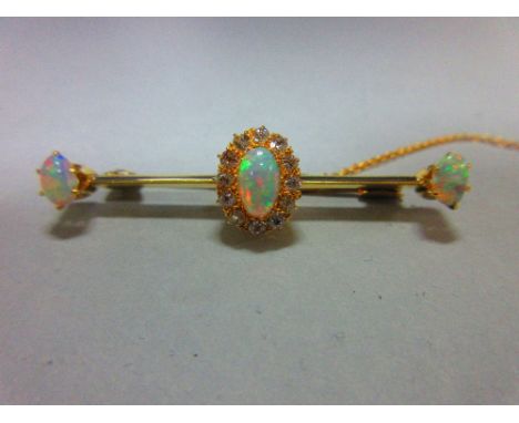 An opal and diamond bar brooch, the knife edge bar set to the centre with an oval cabochon opal in a border of old round cut 