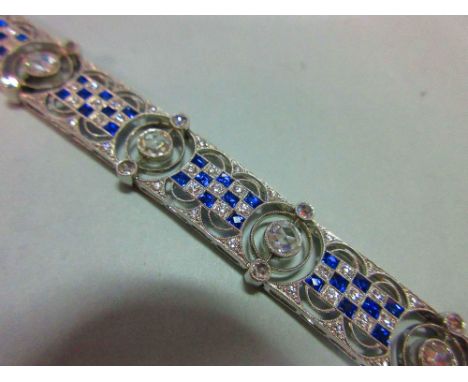 An art deco diamond and sapphire bracelet, designed as nine geometric pierced panels with a central checkerboard line of squa