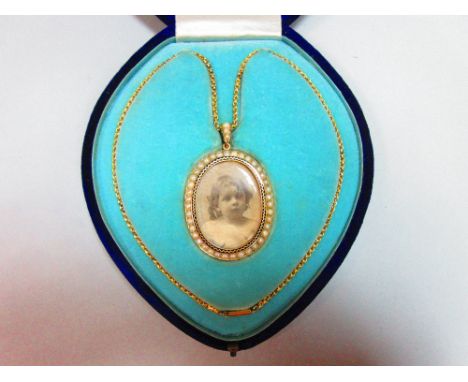A pearl and enamel miniature frame pendant necklace in fitted case, the oval double-sided frame decorated on the front with a