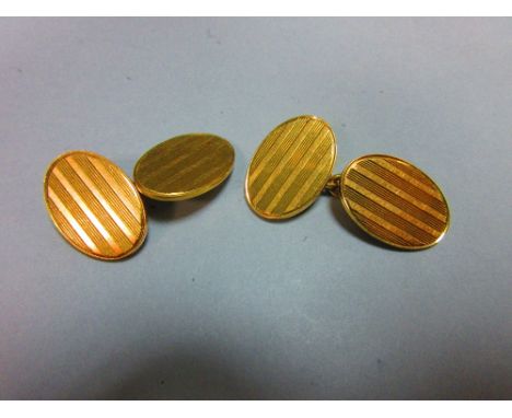 A pair of 18ct gold double-ended cufflinks, each oval end with incised striped decoration, chain connectors, London hallmarks