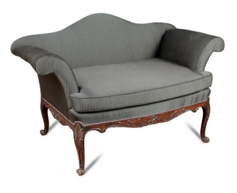 A small George III style mahogany sofa, with camel back and outscrolling arms, carved show wood, upholstered in a dark grey f