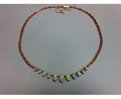 A graduated opal necklace, set to the front with an articulated line of eleven oval cabochon opals to a fancy rectangular lin