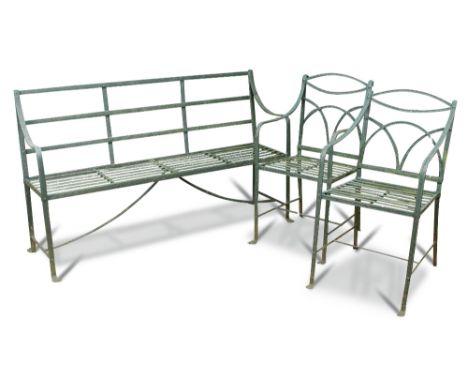 A Regency wrought iron strapwork garden seat, painted green and two similar strapwork chairs on moulded lion paw feet (3) Ben