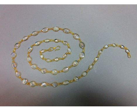 A moonstone necklace, designed as a chain of graduated spectacle set cabochon moonstones joined by very fine wire links, unma
