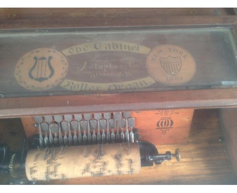 The Cabinet Roller Organ' by 'Autophone, Ithaca, NY' and seventeen wooden cylinders, the rectangular mahogany case with a gla