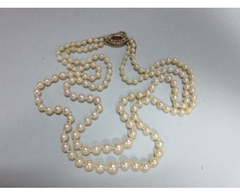 A two row pearl necklace with ruby and diamond clasp, the 3.6 - 8.0mm graduated pearls, to a navette shaped clasp set with a 