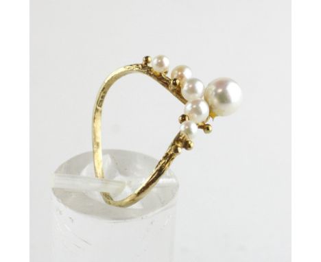 A yellow metal wishbone ring set with six cultured pearls ranging in size from 2.50mm to 5.50mm. Hallmarked 9ct gold, London.