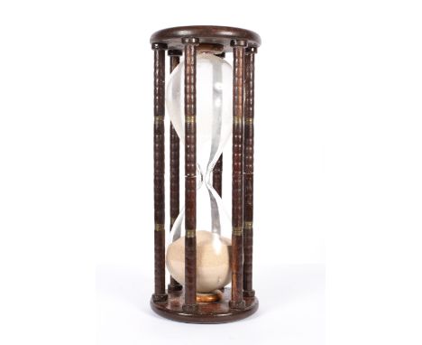 A large vintage hourglass timer, with brass mounted column supports, of traditional form filled with sand, on circular base/t