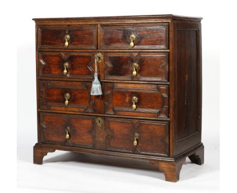 A Carolean style oak chest of two short and three long drawers, probably 18th century, with geometric moulded decoration and 