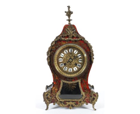 A French Boulle style gilt metal mounted striking mantle clock, late 19th/early 20th century, with flame finial above a scrol