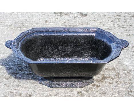 A cast iron planter, of oval form, with cast ribbon decoration, 24cm high x 65cm long x 34cm wide