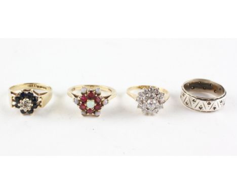 A collection of rings to include: A yellow metal cluster ring set with a central single cut diamond and surrounded by dark bl