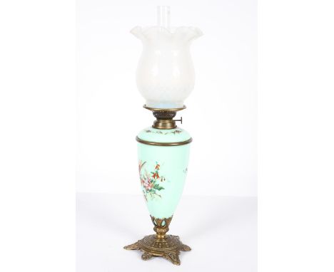 An Edwardian glass, brass and gilt-metal oil lamp, with opaline wrythen moulded shade above a green opaque oviform lamp base 