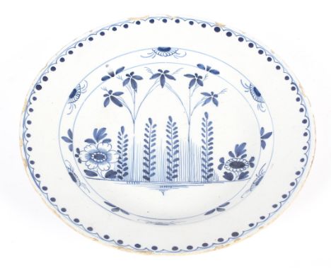 An English delftware blue and white charger, circa 1760, probably London or Bristol, painted with bamboo and chinoiserie shru