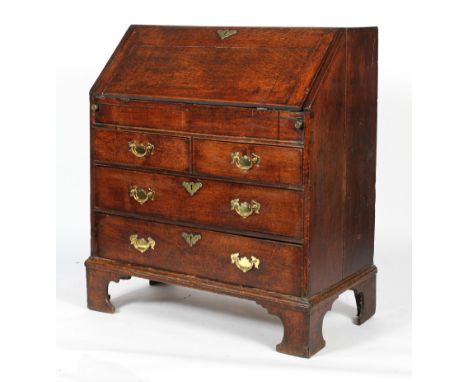 A George III oak bureau, the interior fitted with pigeon holes and drawers (lacking hidden cupboard sliding panel), within fa