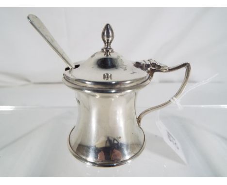 A George V silver hallmarked mustard pot with blue glass liner and spoon, Chester assay 1919 (pot) and 1916 (spoon) by Joseph