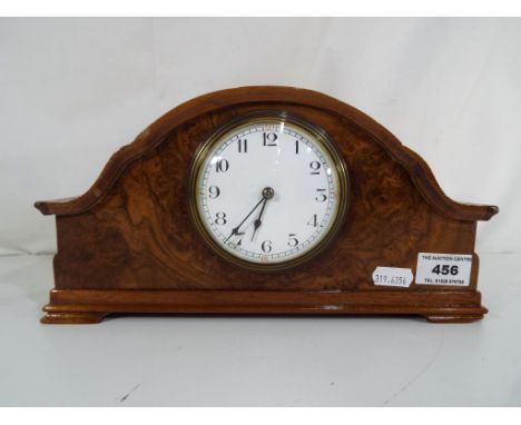 A walnut veneered mantel clock with Arabic numerals to enamel dial, French platform escapement movement marked Made in France