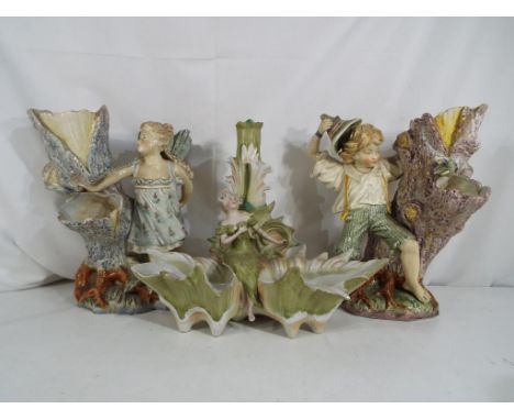 Two European ceramic centre-pieces one depicting a boy and a tree stump, the other a girl, approximately 26 cm (h) also inclu