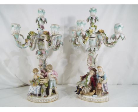 Two European ceramic four-branch candelabra each depicting a couple with floral decoration, approximate height 40 cm (2). Est