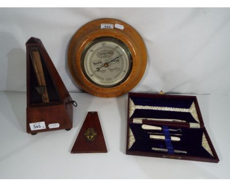 A good mixed lot to include a Maelzel Paquet mahogany cased metronome, cased sewing set and a barometer (3) Est £30 - £50
