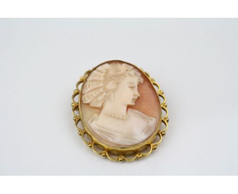 Shell cameo 9ct yellow gold brooch, the cameo depicting female profile, collet setting, scroll and bead surround, length appr