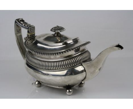 George III silver tea pot raised on four ball feet, repeating bead decoration, gadrooning to upper half of body, angular reed