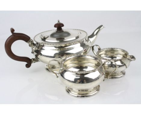 George V silver three piece tea service comprising tea pot, twin handled sugar bowl and milk jug, repeating bead pattern rims