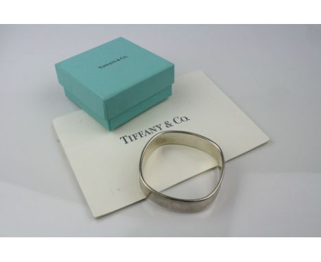 Tiffany &amp; Co silver cushion bangle, stamped 925 T&amp;Co 1837 to centre, width approximately 1.5cm, with original receipt