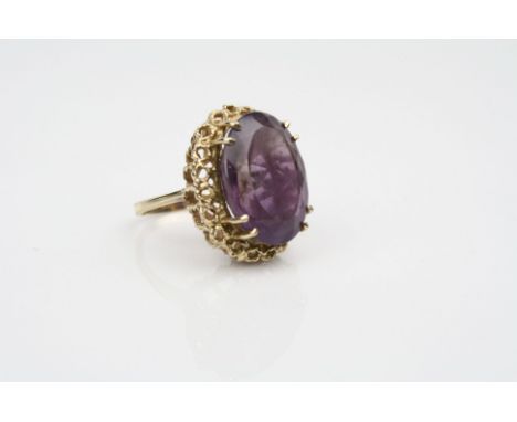 Amethyst 9ct yellow gold dress ring, the oval mixed cut amethyst measuring approximately 20mm x 15mm, claw settings, rope twi