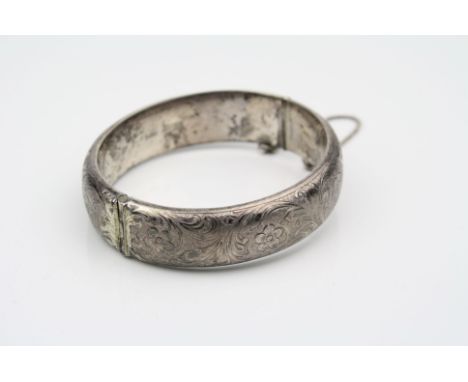 Silver hinged bangle, engraved floral and foliate scroll decoration, tongue and box clasp complete with safety chain, hallmar
