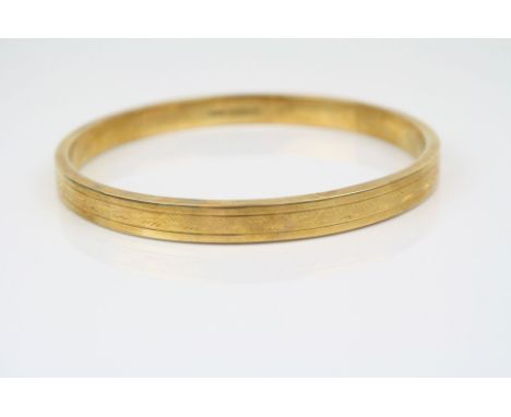 15ct yellow gold bangle, bright cut repeating decoration, width approximately 7mm, inner circumference approximately 23.5cm