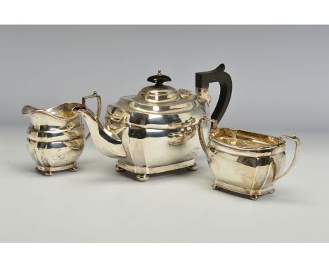 A GEORGE V SILVER THREE PIECE TEA SERVICE, of shaped rectangular form, on flattened bun feet, teapot with black bakelite fitm