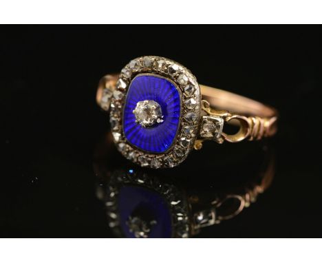 A LATE GEORGIAN GOLD, DIAMOND AND ENAMEL RING, centring on an old mine cut diamond claw set within blue enamel cushion shape 