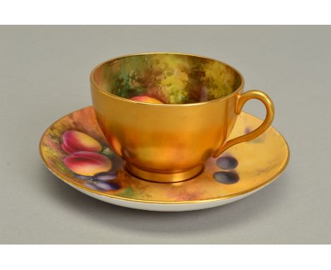 A ROYAL WORCESTER FRUIT STUDY TEACUP AND SAUCER, the exterior of the cup gilded, the interior painted with apples and cherrie
