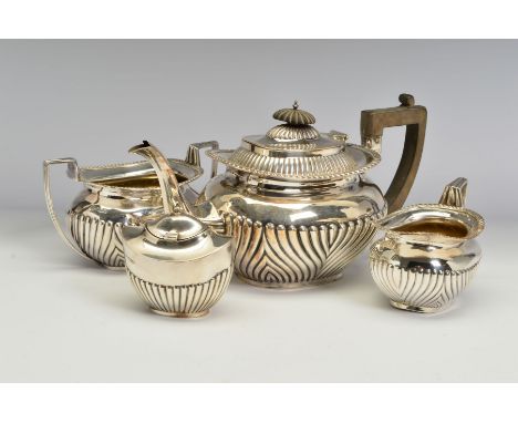 AN EDWARDIAN SILVER THREE PIECE TEA SERVICE, of part reeded oval form, with gadrooned rims, teapot with bakelite fitments, ma
