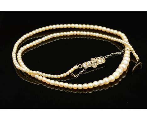 AN EARLY 20TH CENTURY NATURAL SALTWATER PEARL GRADUATED SINGLE ROW PEARL NECKLACE, accompanied by a pearl report from the Gem