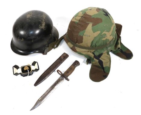A Post War German Helmet, later painted black, with folded brim, leather liner and chin strap; a US Combat Helmet, finished i
