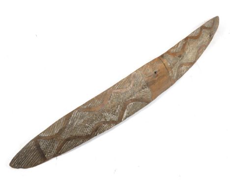 An Early 20th Century Australian Aboriginal Parrying Shield, of elongated triangular section in heavy light brown wood, the c