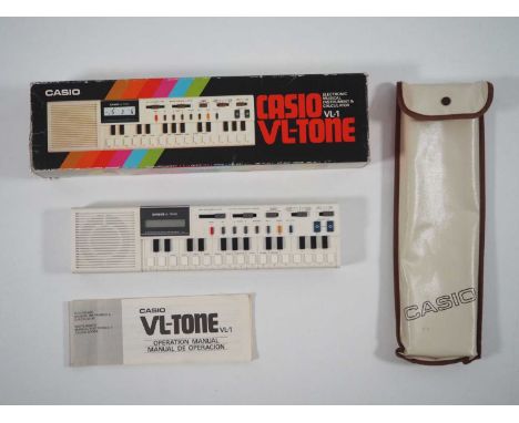 A CASIO VL-Tone VL-1 electronic keyboard - circa early 1980s in original box with original carry case, instructions and music