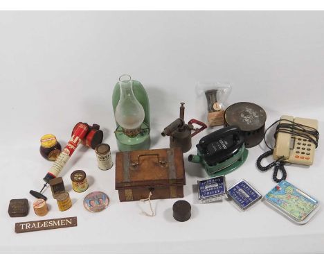 A selection of mid 20th Century homewares to include a 'Radiation Rhythm' iron, metal cashbox, paraffin lamp, condiment tins,