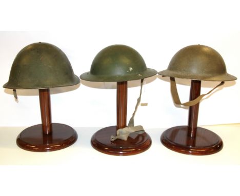 Three British World War II army helmets.