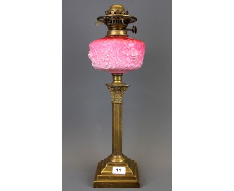 A Victorian brass oil lamp with pink glass well, H. 51cm.
