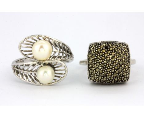 A 925 silver marcasite set ring and a white metal (tested gold plated silver) pearl set ring, (S.5) &amp; (O.5).