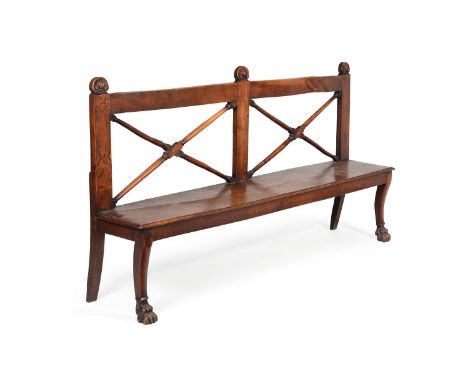 An Irish Regency oak hall bench, circa 1815, the top rail with shell carved finials, above twin X-shaped splats, the solid se