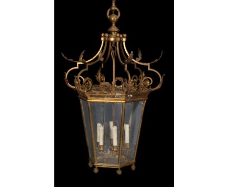 A gilt metal and glazed hexagonal hall lantern, late 19th/early 20th century, probably English or French, the scrolled ceilin