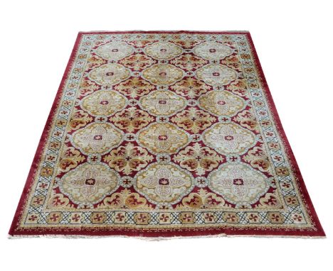 A Tetex carpet, the crimson, ochre and cream field incorporating stylised flowerhead motifs, approximately 400 x 300cm